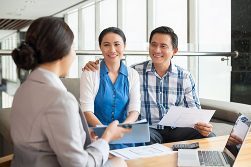 Asian couple applying for a Non-QM mortgage in an office setting.